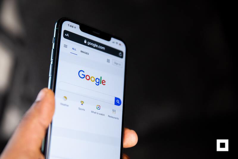 Person holding a smartphone with Google on screen
