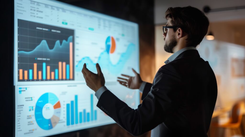 A marketing strategist giving a presentation on market trends and forecasts with a large screen displaying dynamic data | Impressions Agency A marketing strategist presenting market trends and forecasts using marketing tools on a large screen with dynamic SEO and PPC data.