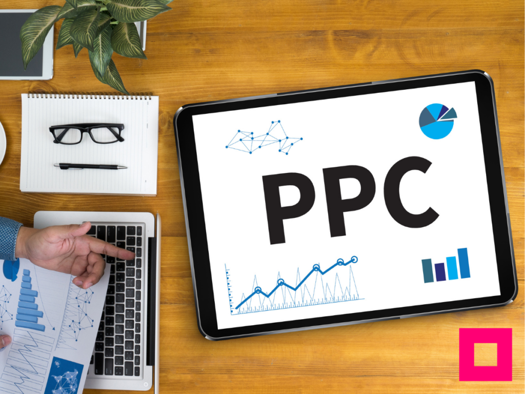 Person’s hand holding a paper displaying Pay per click campaign data, with PPC text and marketing graphs on papers.