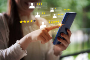 Woman giving a star rating on her mobile phone, illustrating reputation management and online review evaluation for business credibility.